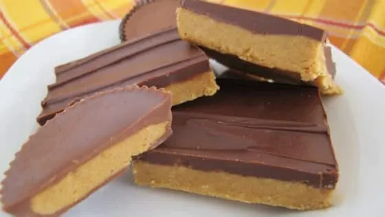 Barras de crema de cacahuate cubiertas con una capa lisa de chocolate, cortadas y servidas en un plato